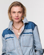 Woman wearing a blue denim shirt with a white background