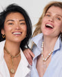 Two women wearing necklaces against a white background
