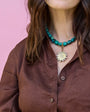 Woman wearing a brown shirt with a pink background