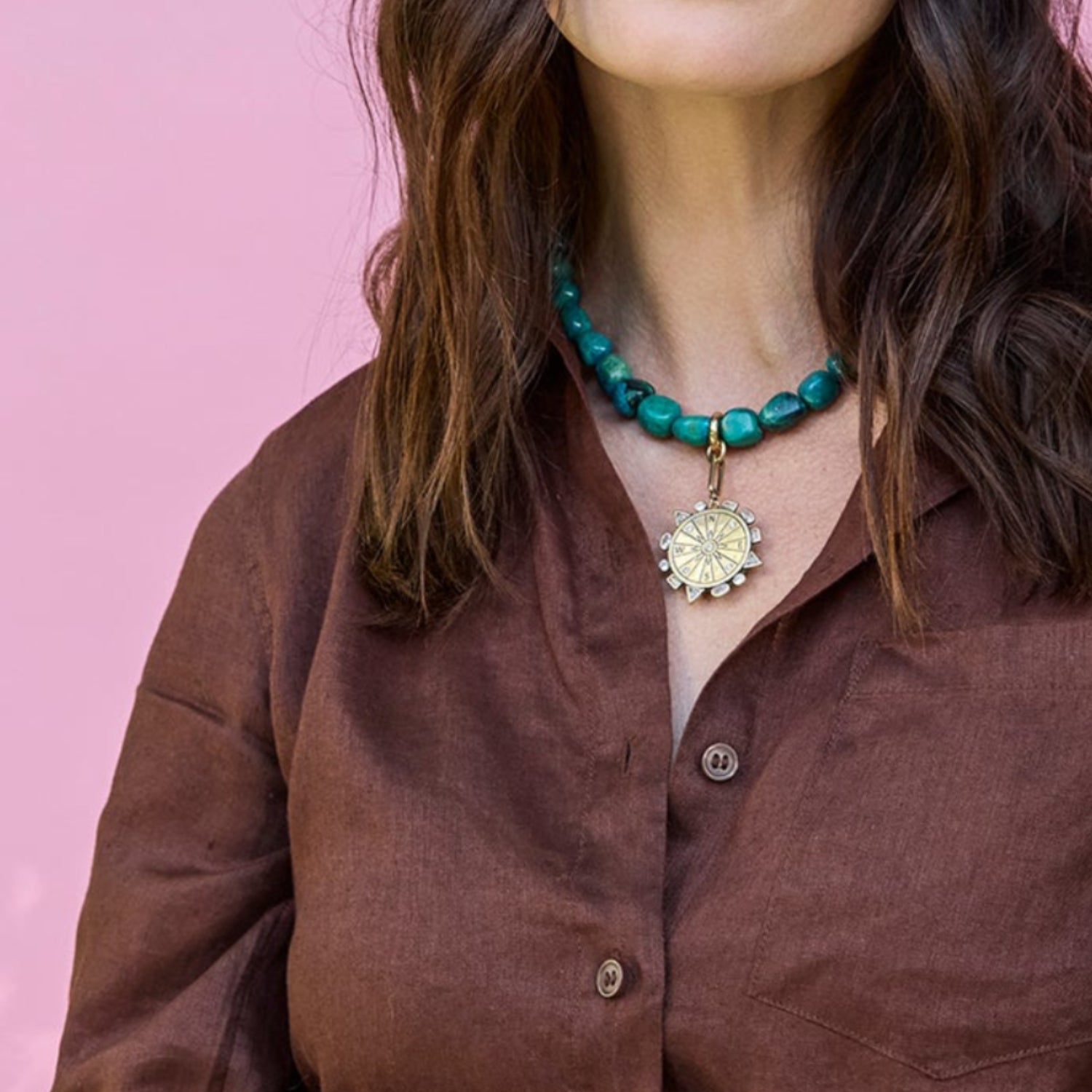 Woman wearing a brown shirt with a pink background
