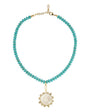 Turquoise beaded necklace with a gold pendant on a white background