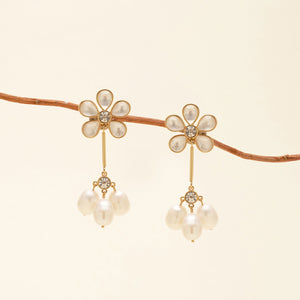 Crystal, Pearl, and Gold Flower Drop Earrings Staged on Branch with Tan Background