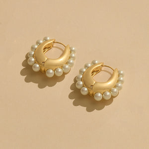 Gold and Pearl Hoop Earrings on Tan Background