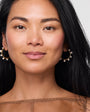 Model wearing pearl and gold hoop earring