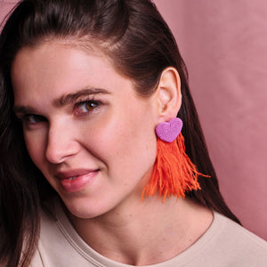 Pink Beaded Heart Earrings with Red Statement Feathers Styled on Model