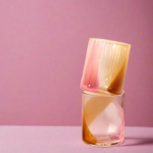 Pink, Peach, Cream, and Amber Glass Cups Stacked on Pink Background