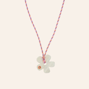 Pink Cord and White Flower Pendant Necklace on Tan Background