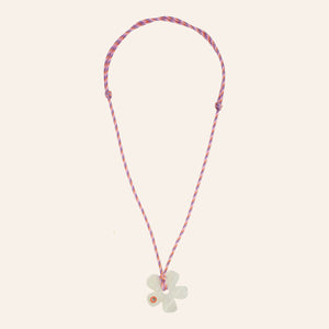 Pink Cord and White Flower Pendant Necklace on Tan Background