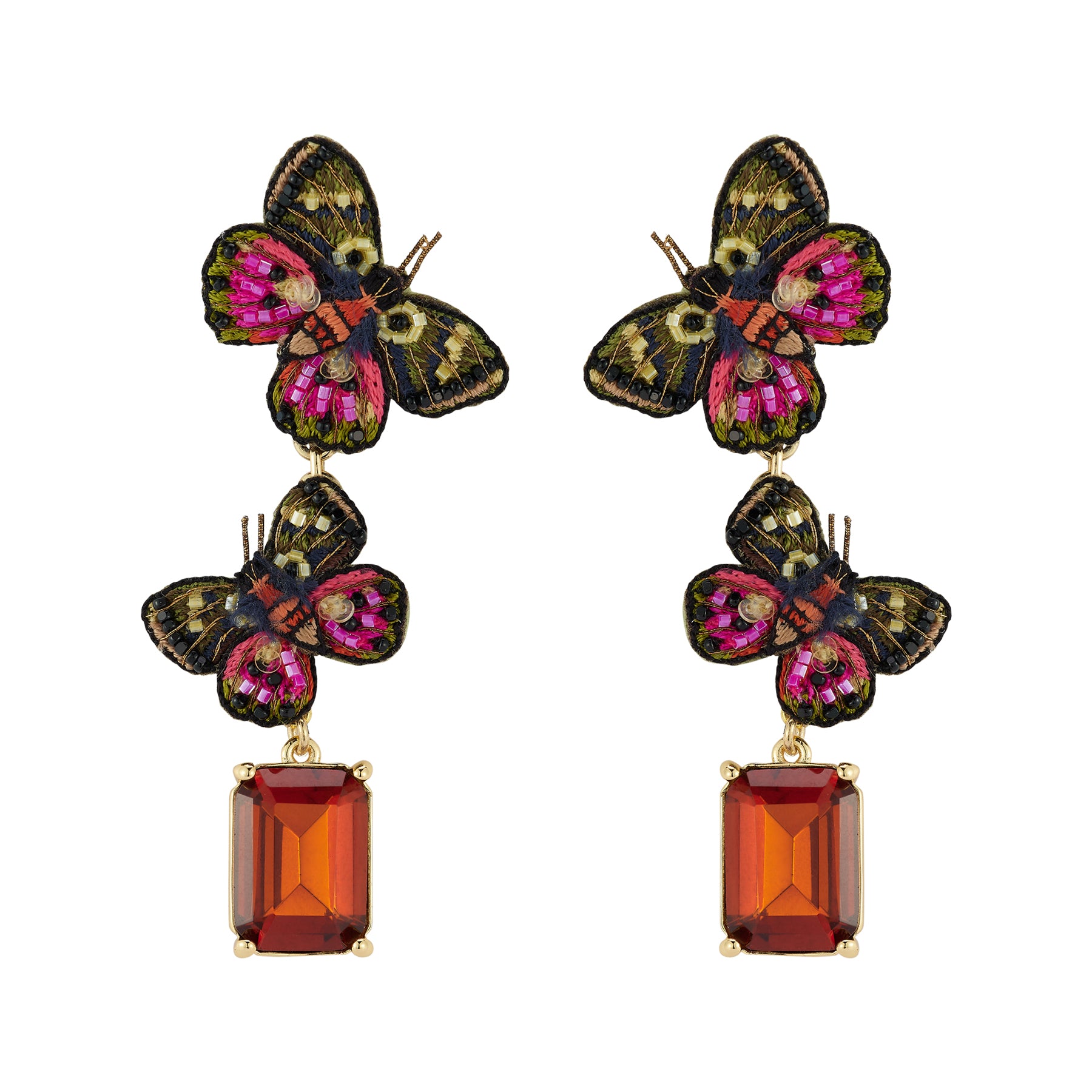 Butterfly-shaped earrings with red gemstones on a white background