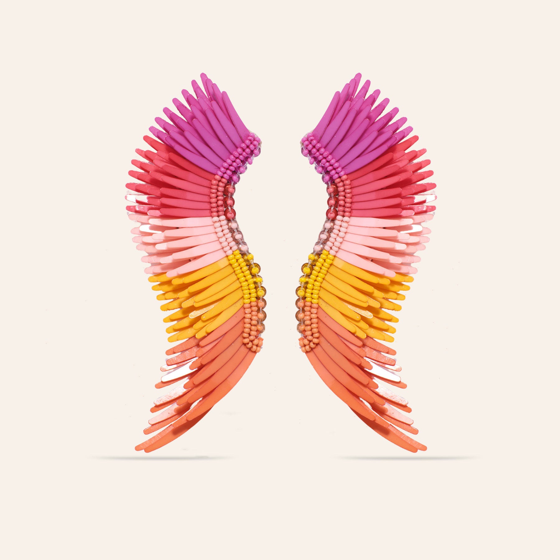 Pink, Yellow, and Orange Sequin Wing Earrings on Tan Background