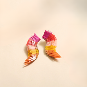 Pink, Yellow, and Orange Sequin Wing Earrings on Tan Background