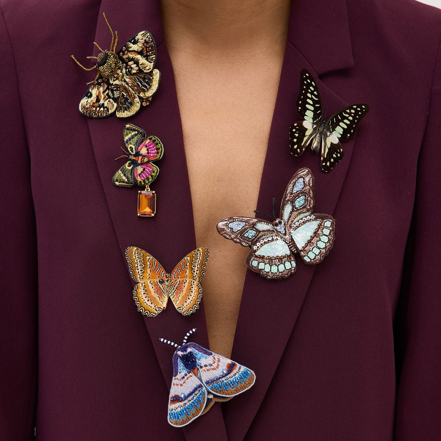 Maroon blazer with colorful butterfly brooches