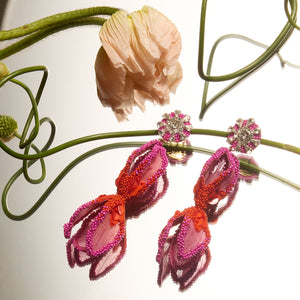 Pink and Red Beaded and Embroidered Flower Earrings Staged with Flowers on Mirrored Background