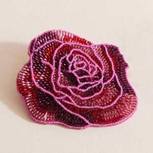 Pink Beaded Flower Brooch on Tan Background