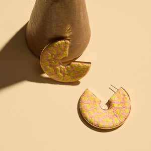 Yellow and Pink Embroidered Leopard Hoops Staged with Vase on Cream Surface