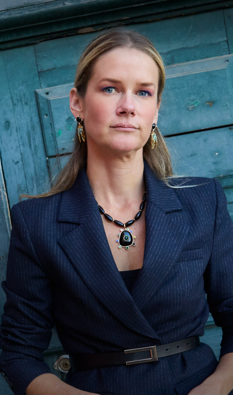Model Wearing Black Onyx Statement Necklace and Cicada Inspired Earrings on a  blue background