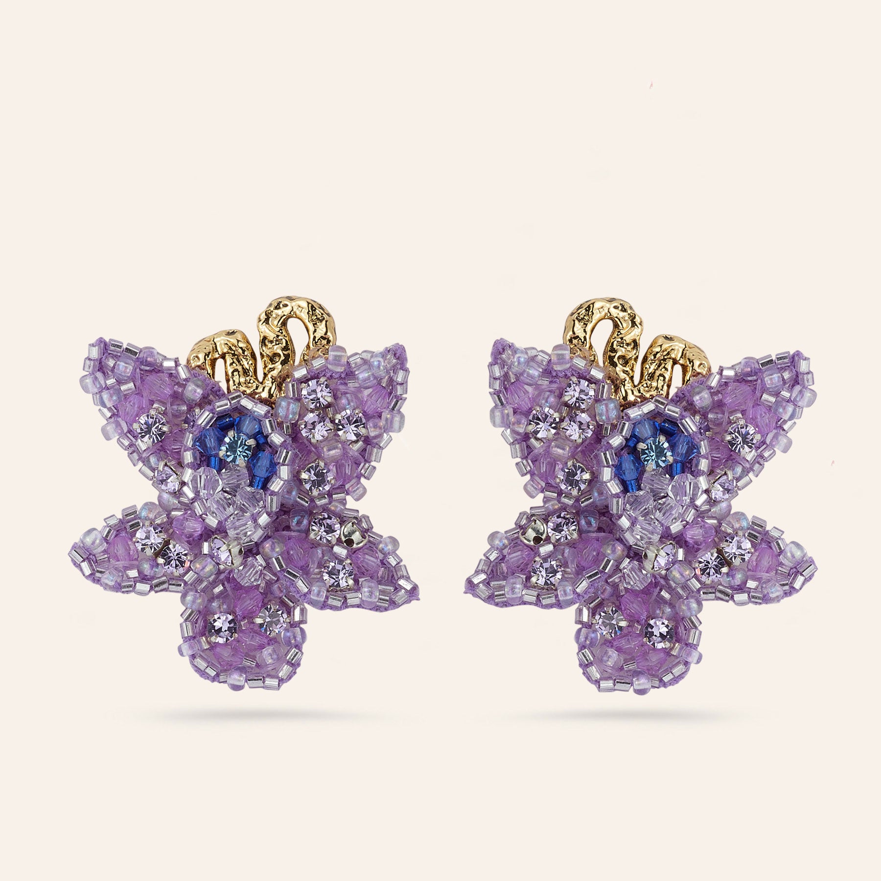 Purple and Blue Beaded Flower Drop Earrings on Tan Background