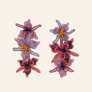 Purple and Pink Linear Drop Flower Earrings on Tan Background
