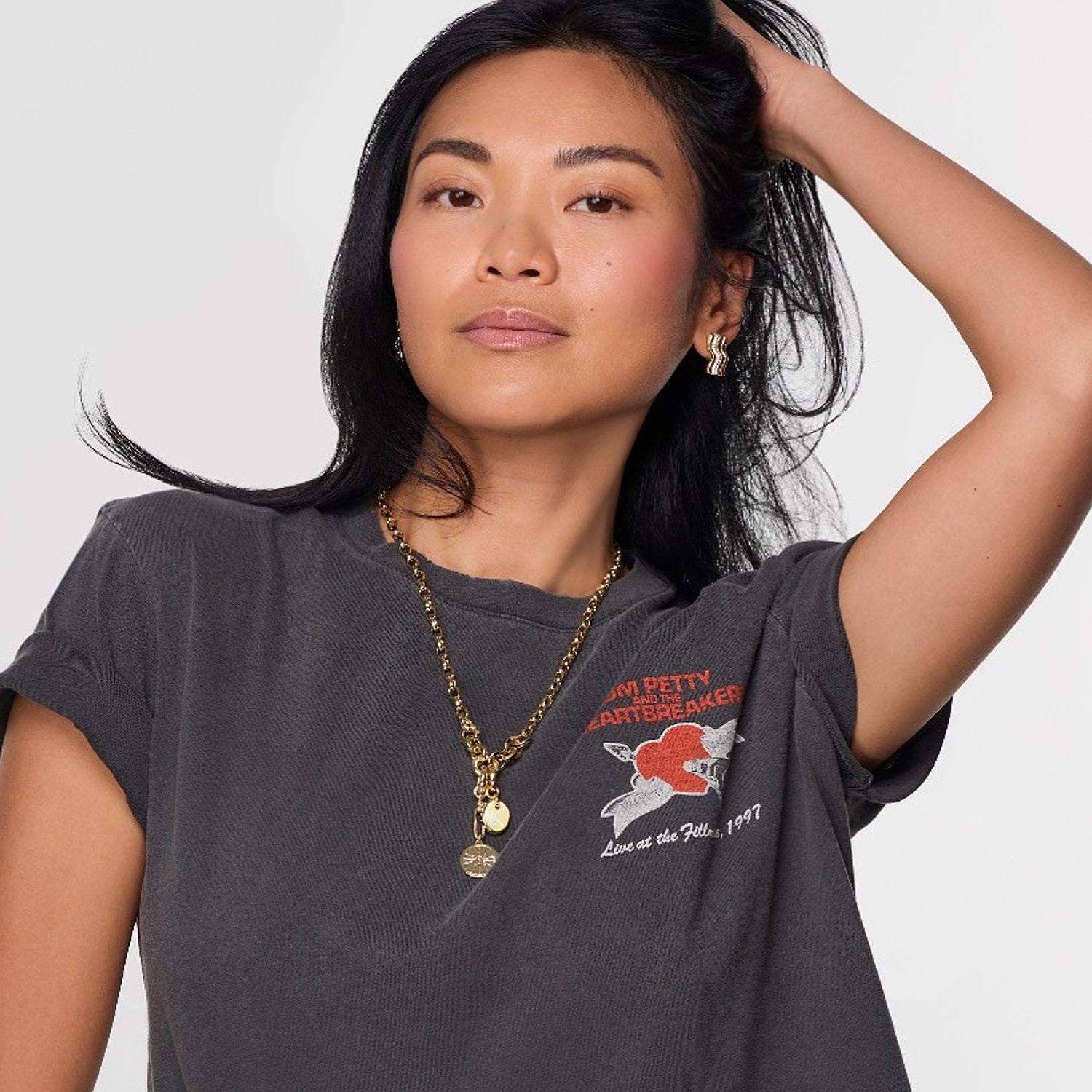 Mondel wearing gold studs and necklace