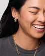 Model wearing gold and crystal stud earrings
