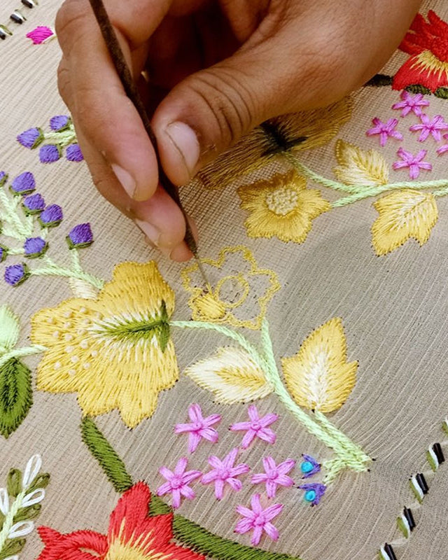 Close-up of hand embroidery with colorful floral patterns on fabric