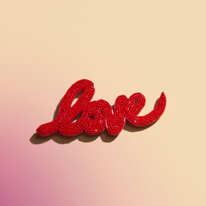 Red Beaded and Embroidered Love Brooch on Ombre Pink and Orange Background