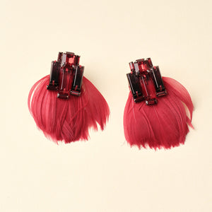 Red Feather and Crystal Drop Earrings on Tan Background