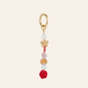 Red, Pink, White, Neutral Beaded Bag Charm on Tan Background