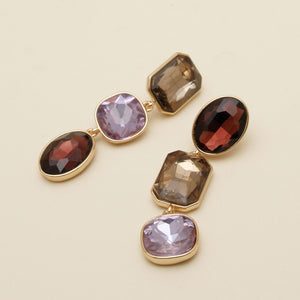 Brown, Red, and Purple Drop Earrings on Tan Background