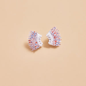 White Sequin Wing Earrings with Red and Blue Splatter Paint on Tan Background