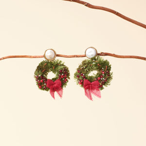 Red and Green Pearl Drop Wreath Earrings Staged on Branch with Tan Background