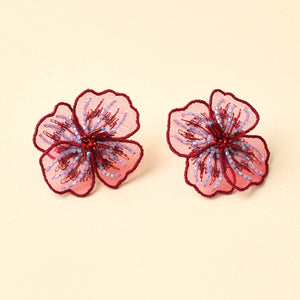 Red and Purple Beaded and Embroidered Flower Stud Earrings on Tan Background