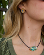 Model wearing gold studs and green cord necklace 