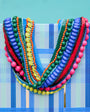 Colorful beaded necklace on a blue and white striped fabric background