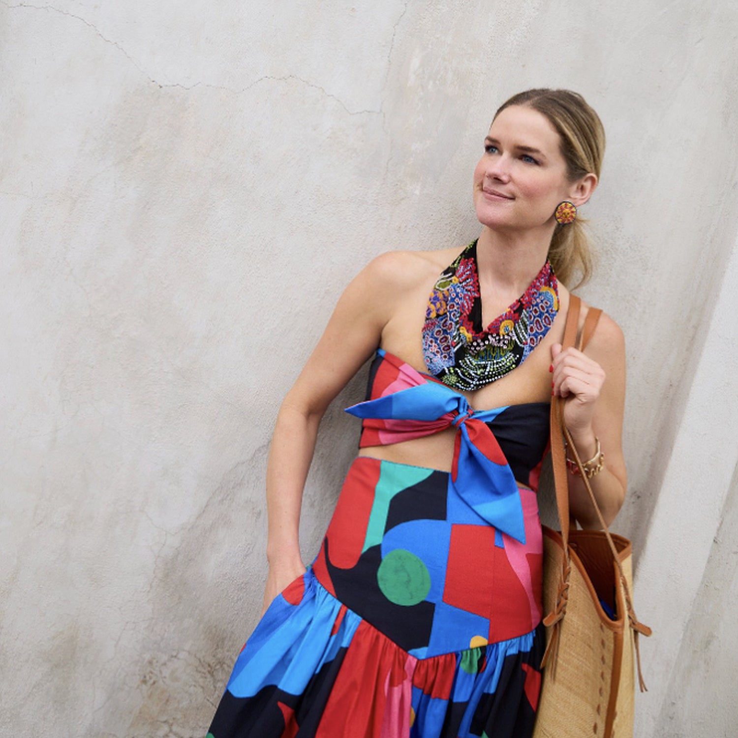 Beaded scarf and colorful dress on model on stone background