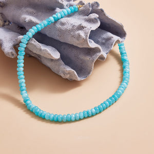 Blue Beaded Collar Staged on Shell with Tan Background