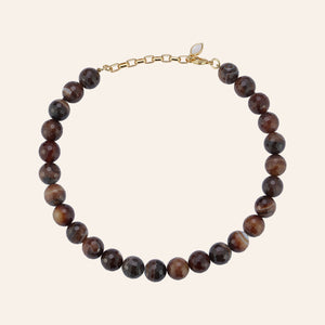 Brown Beaded Strand Necklace on Tan Background
