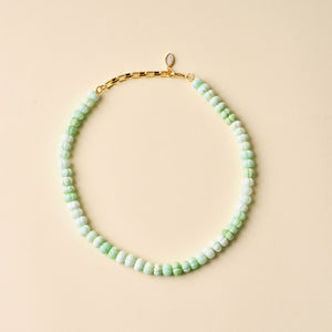 Green Beaded Strand Necklace on Tan Background