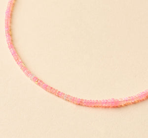 Pink Beaded Strand Necklace on Tan Background