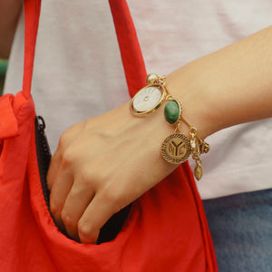 Stone, Gold, and Pearl Charm Bracelet Styled on Model's Wrist with Red Purse