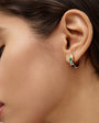 Close-up of a woman's ear wearing a colorful stone hoop earring.