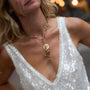 Close-up of a person wearing a gold necklace with a sequin top.