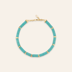 Turquoise and Gold Beaded Strand on Tan Background