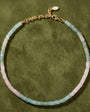 A delicate beaded necklace with alternating segments of light blue-green and pale pink translucent beads, finished with a gold-tone chain and lobster clasp.