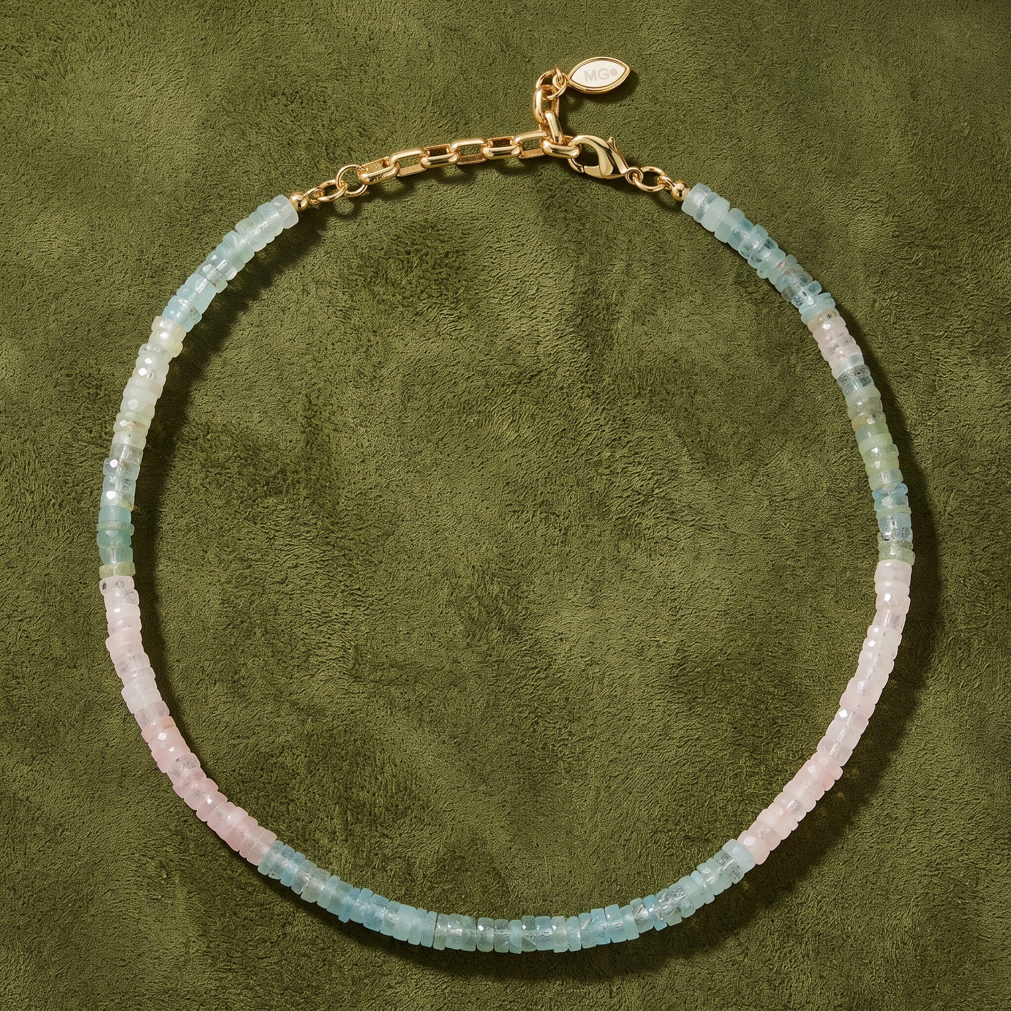 A delicate beaded necklace with alternating segments of light blue-green and pale pink translucent beads, finished with a gold-tone chain and lobster clasp.
