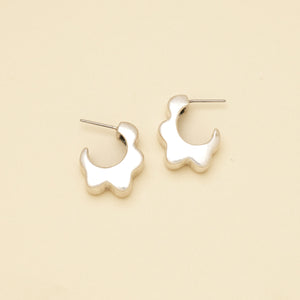 Silver Wavy Hoop Earrings on Cream Background