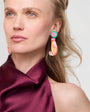 Woman wearing colorful Sirena Earrings with a plain background