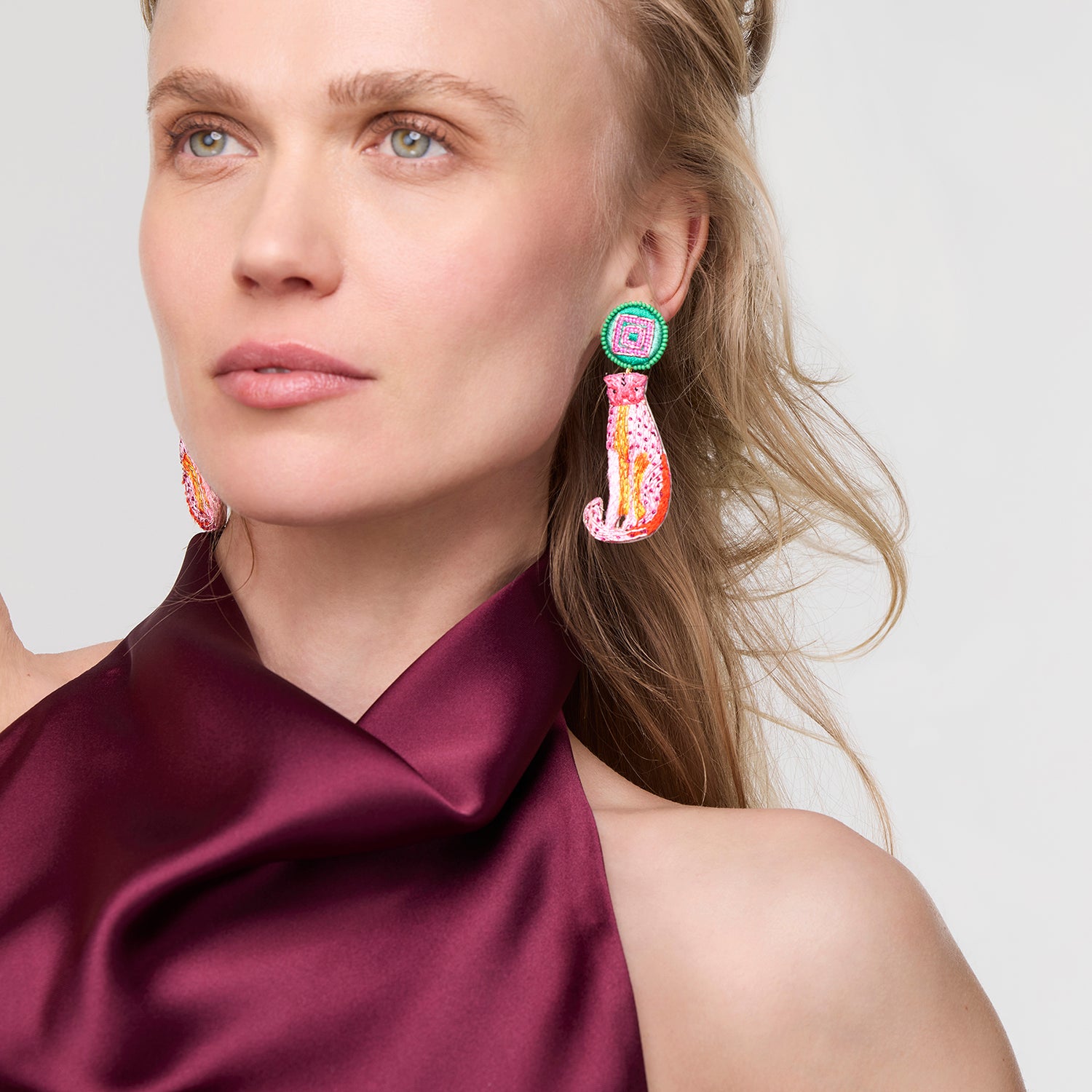 Woman wearing colorful Sirena Earrings with a plain background