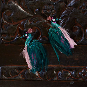 Teal and Pink Embroidered and Feather Earrings Staged on Carved Wood Surface