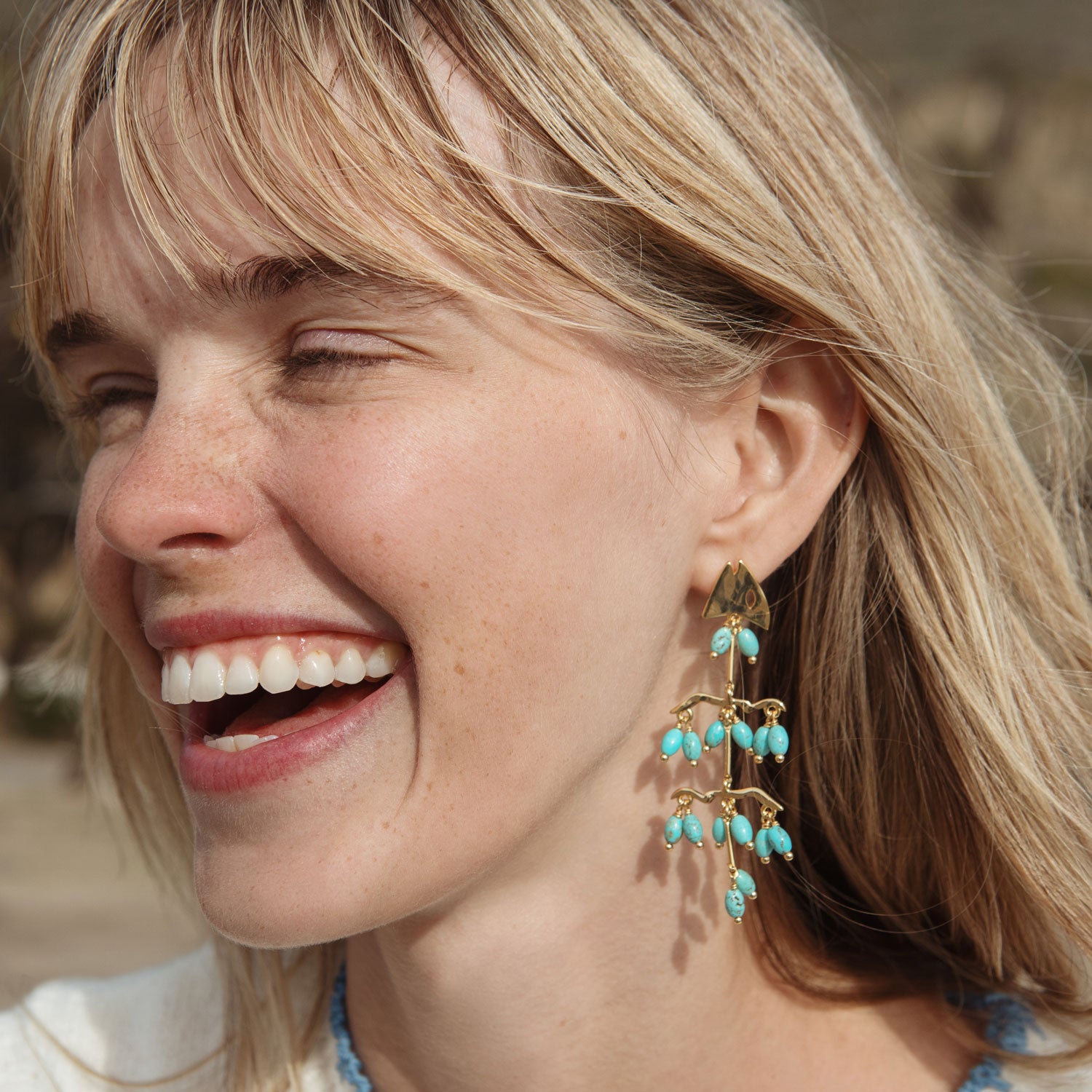 Turquoise Stone and Gold Fish Skeleton Earrings Styled on Model